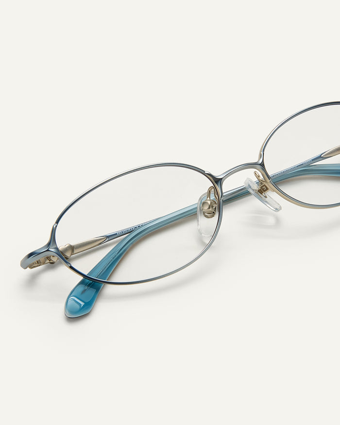 Close up shot of Bonnie Clyde Bunny optical frames in stainless steel in layered blue with clear lens.