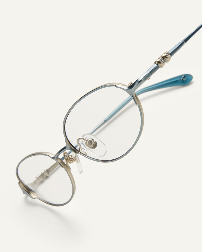 Side shot of Bonnie Clyde Bunny optical frames in stainless steel in layered blue with clear lens.
