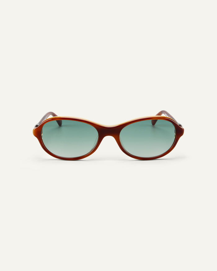 Face shot of Bonnie Clyde Butter Knife sunglasses in layered brown with green lenses.