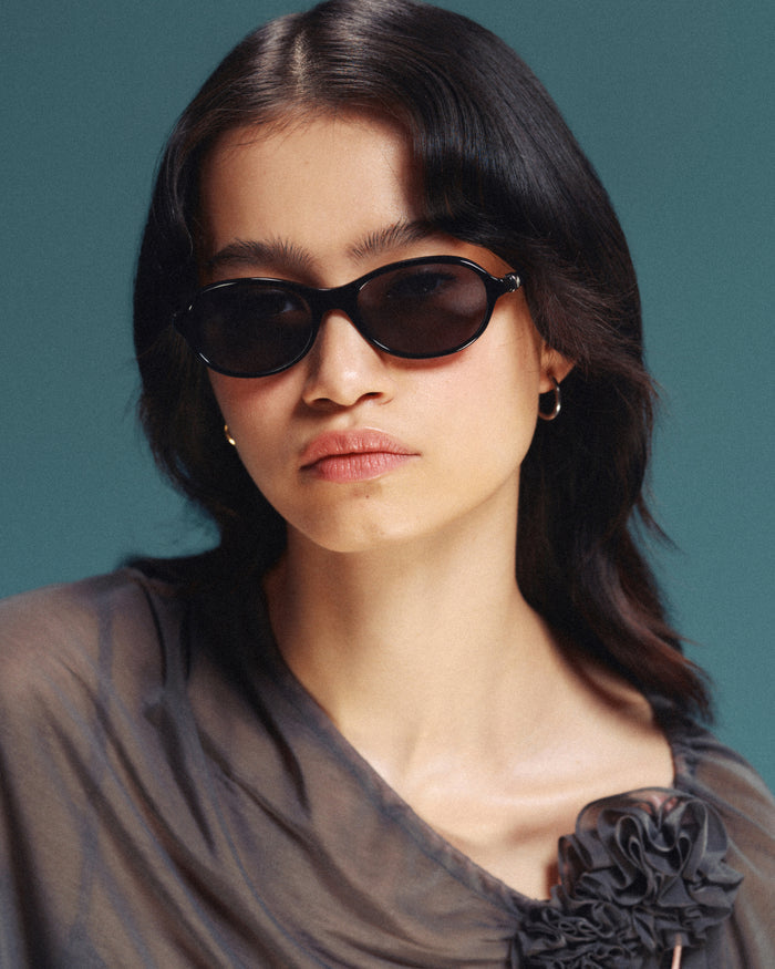 Quarter shot of Bonnie Clyde Butter Knife sunglasses in black with black lenses.
