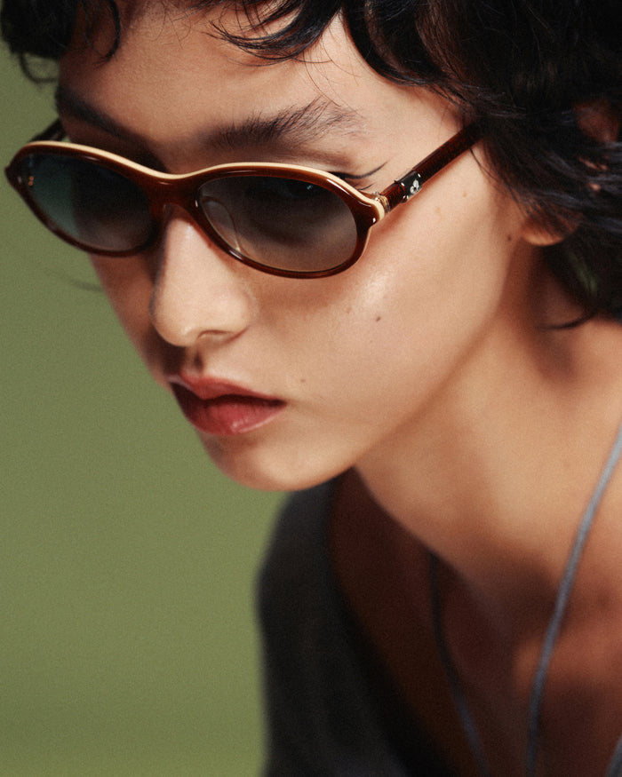Side shot of Bonnie Clyde Butter Knife sunglasses in layered brown with green lenses.