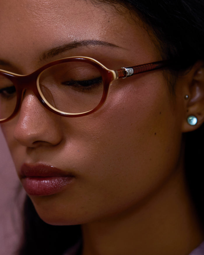 Close-up shot of Bonnie Clyde Butter Knife optical frames in layered brown with clear lenses.