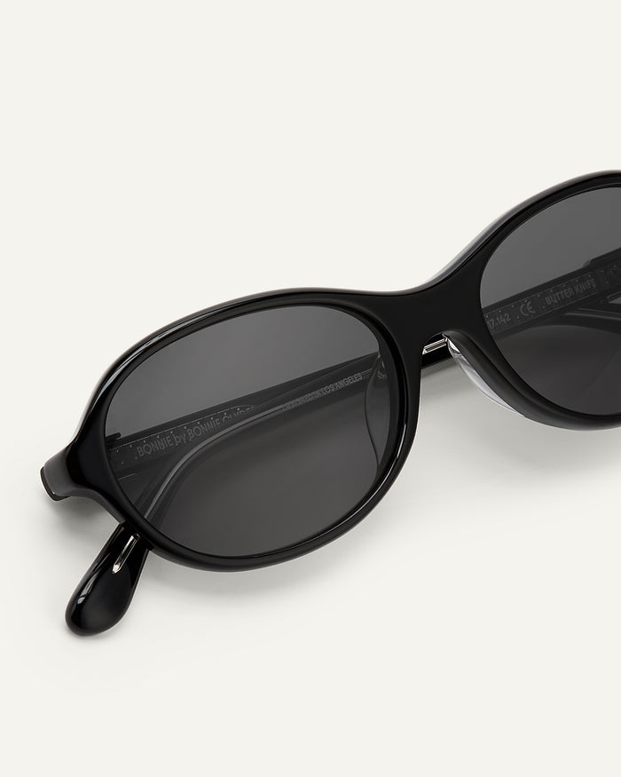 Close-up shot of Bonnie Clyde Butter Knife sunglasses in black with black lenses.