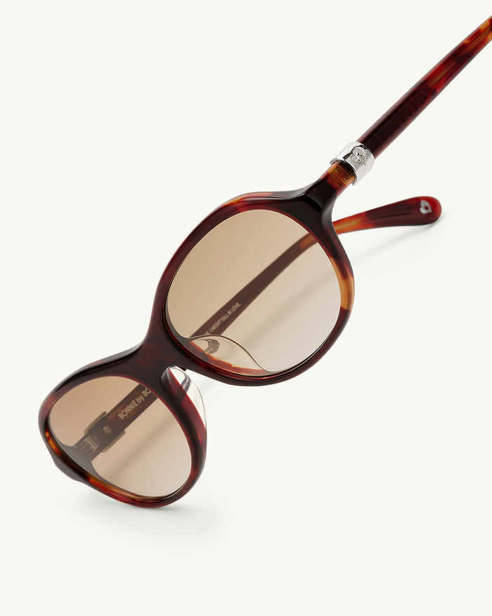 Detail shot of Bonnie Clyde Butter Knife sunglasses in red tortoise with brown lenses.