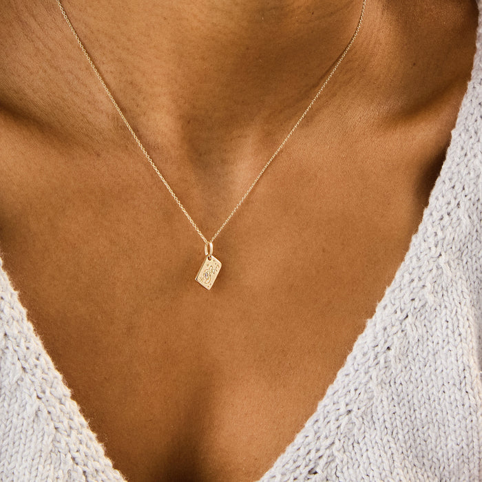 Calgary Postcard Charm in 10k yellow gold with brilliant diamond, shown worn on hand