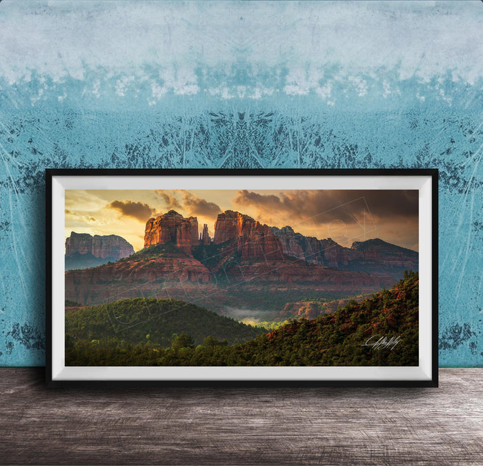 The image is a framed photograph of a scenic landscape with mountains and a sunset sky.
