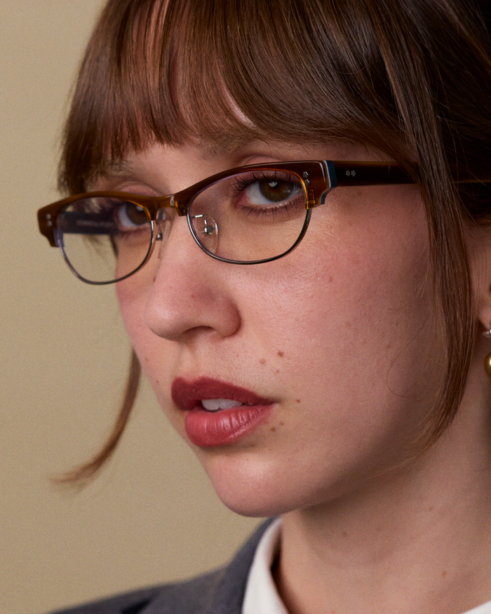 Quarter shot of Bonnie Clyde CC optical frames in layered demi teal with clear lenses.