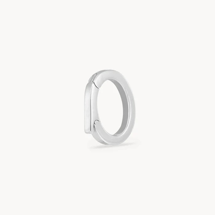 A closed polished silver charm holder shown from a side profile view against a clean, off-white background.