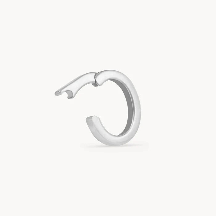 An opened polished silver charm holder shown from a side profile view against a clean, off-white background.