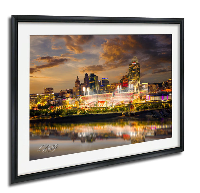 a city skyline at night, with tall buildings illuminated by colorful lights. The city is reflected in the water below, creating a beautiful and vibrant scene.
