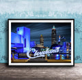 A framed photograph of the Cleveland skyline at night, with the city's iconic landmarks illuminated against a dark sky.