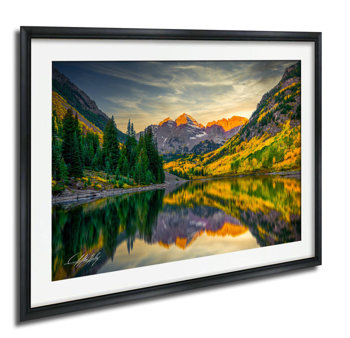 a serene mountain landscape with a lake reflecting the vibrant colors of the autumn foliage.