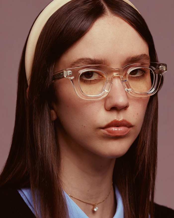 Quarter shot of Bonnie Clyde Crybaby optical frames in transparent yellow with clear lenses.