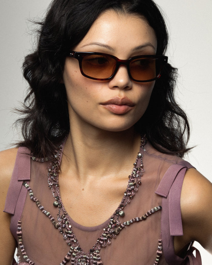Close-up shot of Bonnie Clyde Dagger sunglasses in red tortoise with brown lenses.