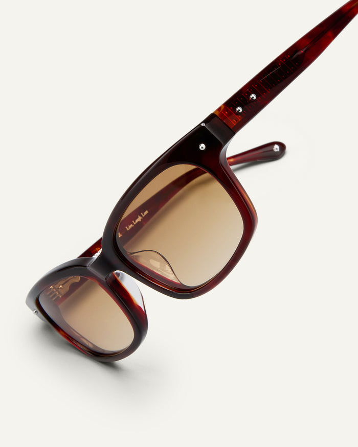Detail shot of Bonnie Clyde Dagger sunglasses in red tortoise with brown lenses.