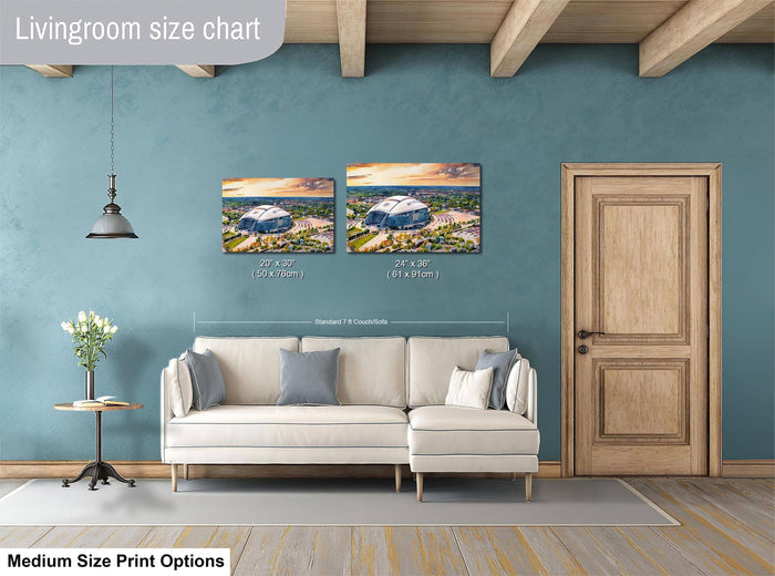 a living room with a white sofa, a wooden door, and a painting of a stadium on the wall. The painting is of a size chart for medium-sized prints, indicating the dimensions of the artwork.