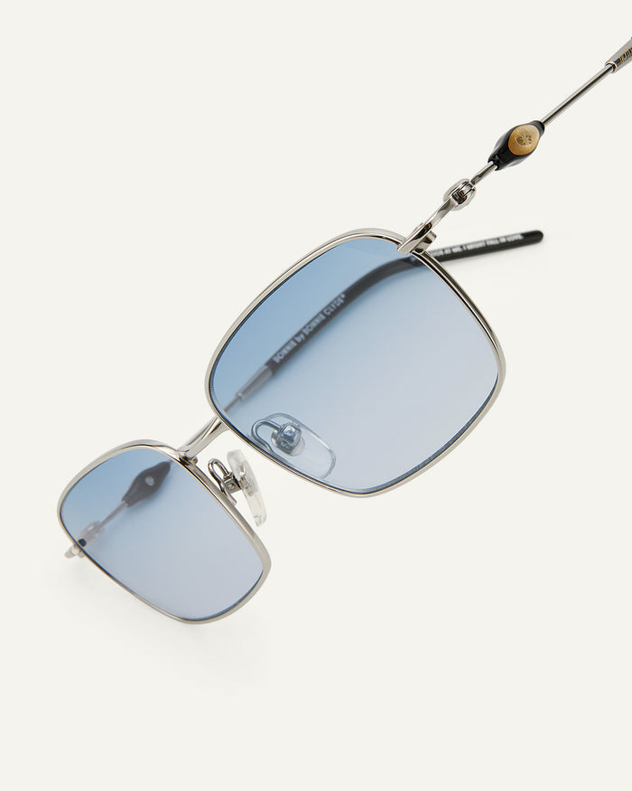 Side shot of Bonnie Clyde Dance Dance sunglasses in silver and black with blue gradient lenses.