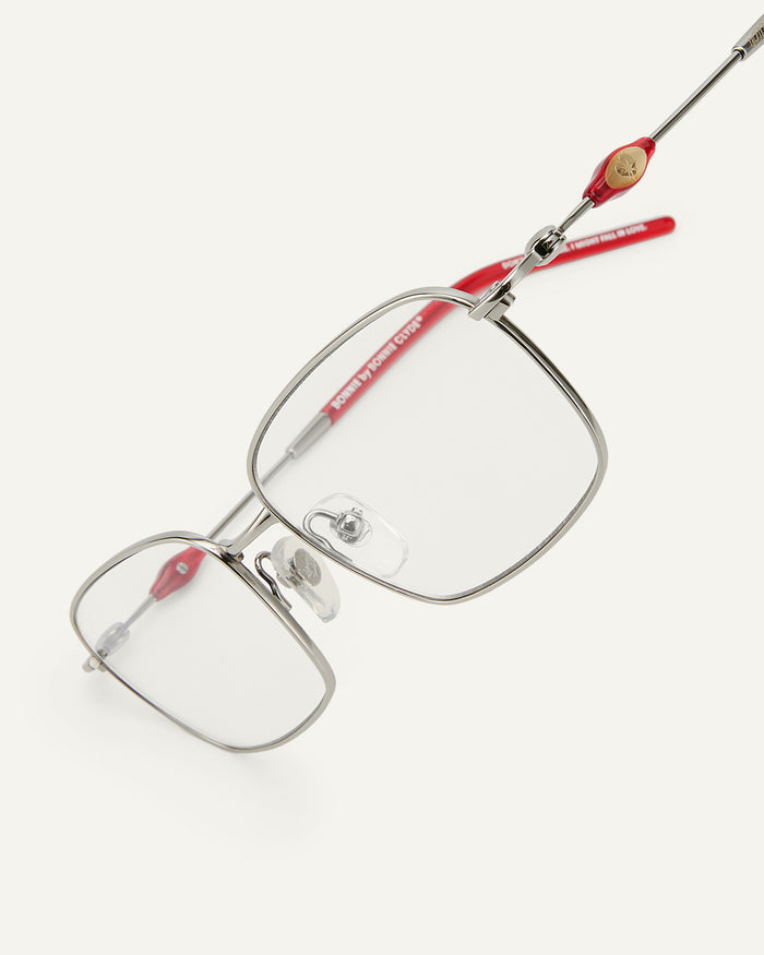 Close-up shot of Bonnie Clyde Dance Dance optical frames in silver and layered red with clear lenses.