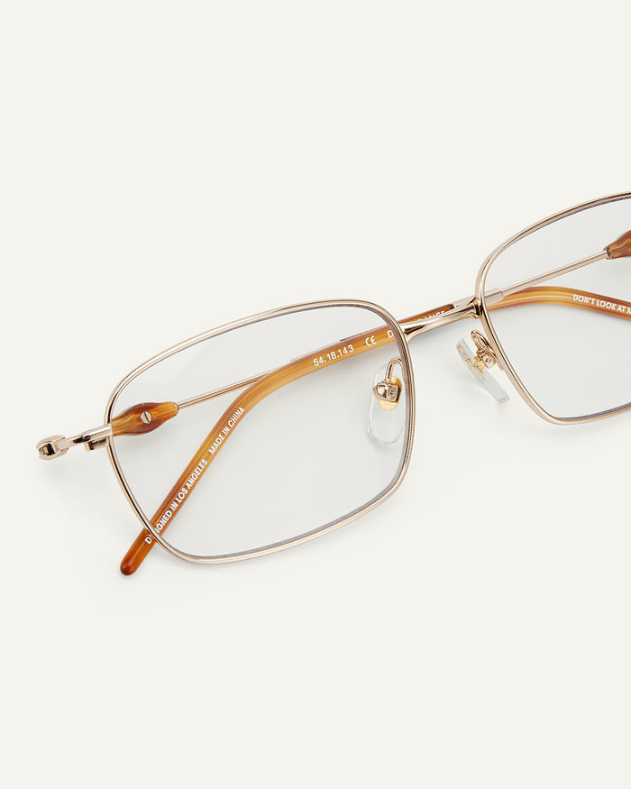 Close-up shot of Bonnie Clyde Dance Dance optical frames in gold and yellow tortoise with clear lenses.