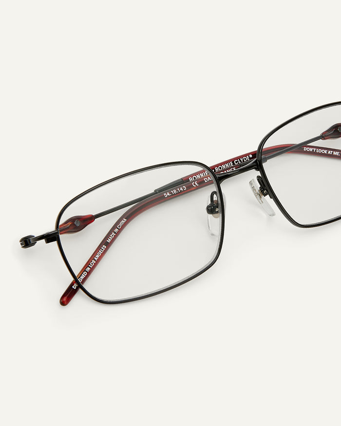 Close-up shot of Bonnie Clyde Dance Dance optical frames in black and red tortoise with clear lenses.