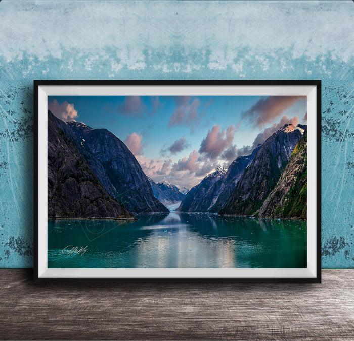 The image is a framed photograph of a serene mountain lake, with a stunning view of the mountains and the calm waters reflecting the sky.