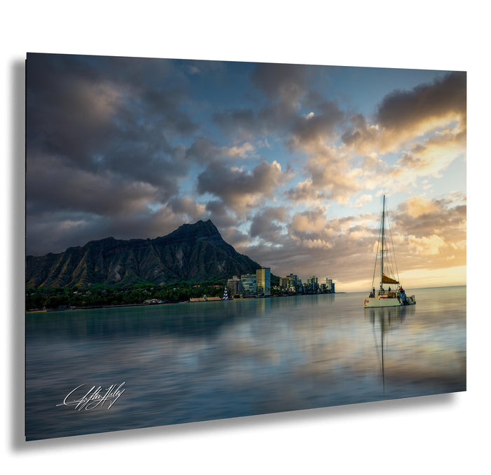 a serene scene of a sailboat gently floating on a calm body of water, with a city skyline in the background and a majestic mountain range in the distance.