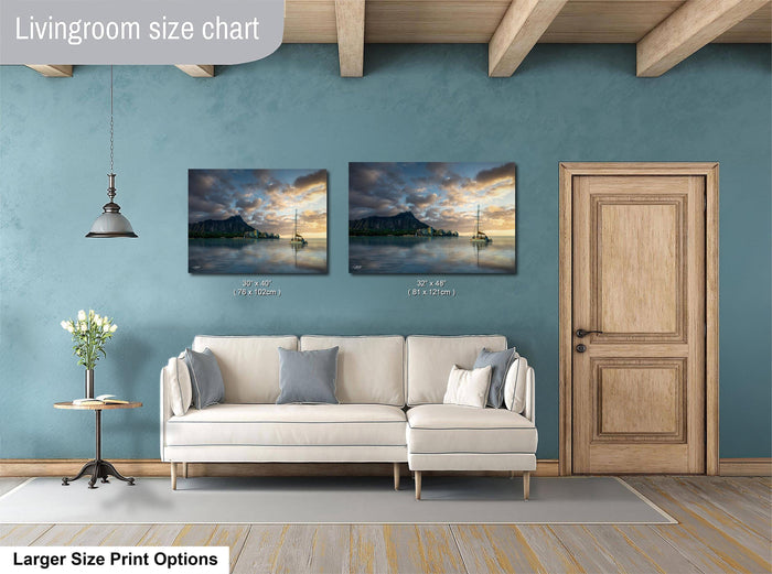 a living room with a white sofa, a wooden door, and two framed pictures of a sunset over a body of water.