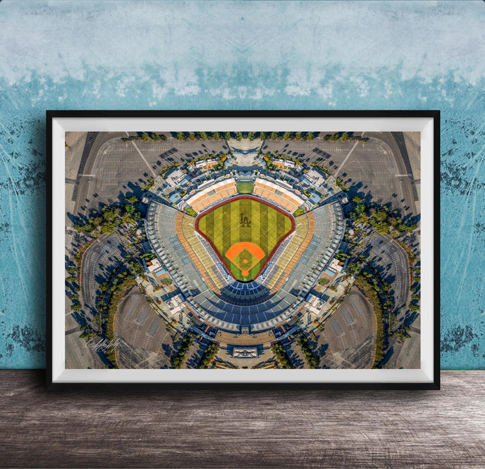 The image is an aerial view of a baseball stadium, featuring a large field surrounded by parking lots and other structures.