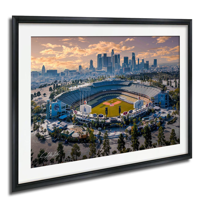 An aerial view of a baseball stadium in a city, with the city skyline in the background.