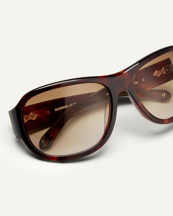 Detail shot of Bonnie Clyde Dog sunglasses in red tortoise with brown gradient lenses.