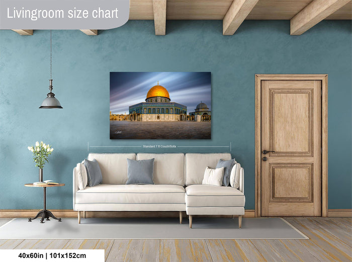 a living room with a large white sofa, a wooden door, and a framed photograph of the Dome of the Rock, a significant landmark in Jerusalem, Israel.