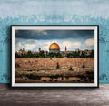 the Dome of the Rock, a significant landmark in Jerusalem, Israel. The photograph is framed and displayed on a wooden surface, showcasing the architectural beauty of the structure against a cloudy sky.