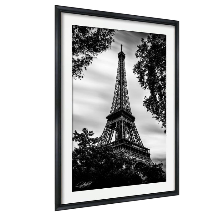 A black and white photograph of the Eiffel Tower in Paris, France, framed and displayed on a wall.