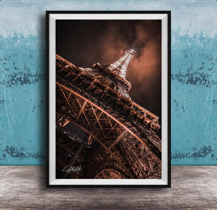 a close-up view of the Eiffel Tower, showcasing its intricate metal lattice structure and the surrounding night sky.