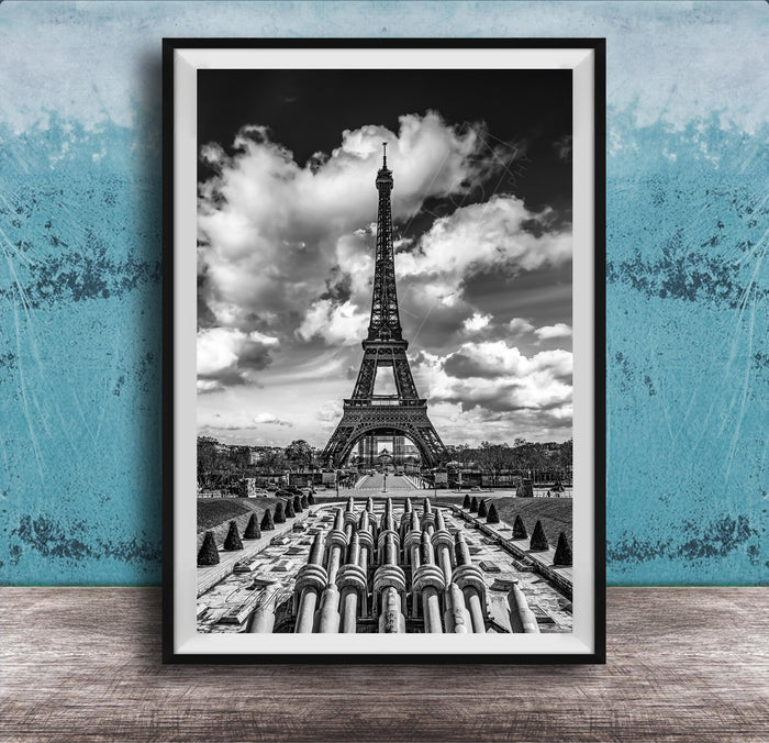 A black and white photograph of the Eiffel Tower in Paris, France, with a cloudy sky in the background.