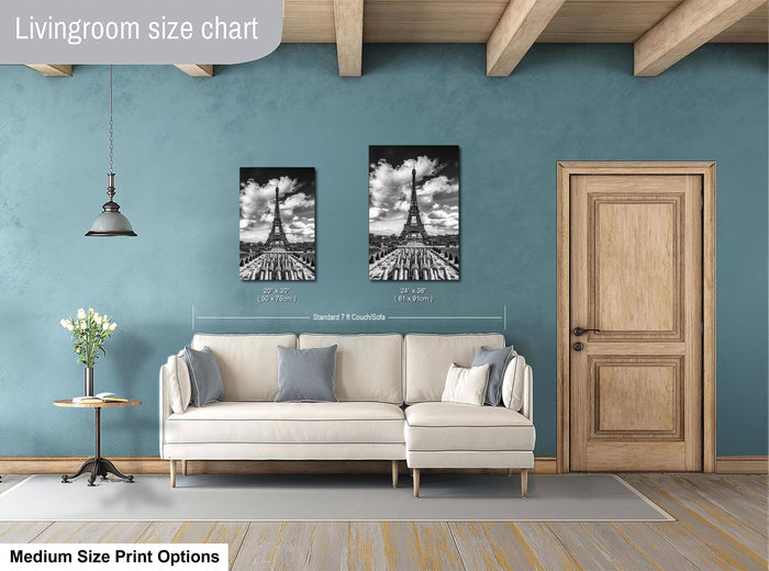 a living room with a white sofa, a wooden door, and a framed picture of the Eiffel Tower on the wall.