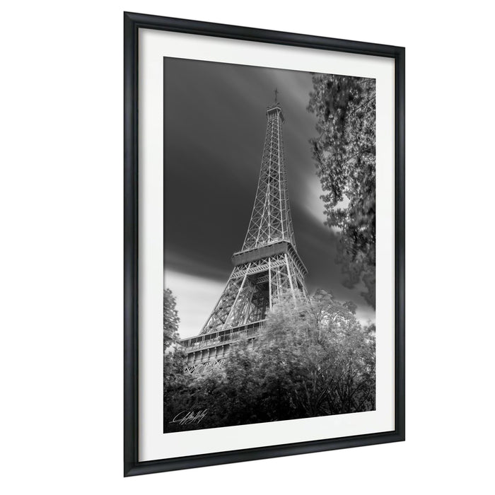 A black and white photograph of the Eiffel Tower in Paris, France, with a cloudy sky in the background.
