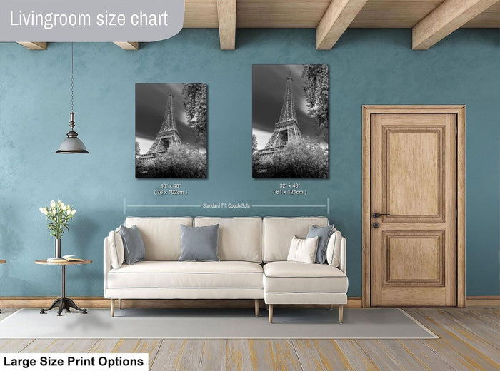 a living room with a white sofa, a wooden door, and a framed photograph of the Eiffel Tower on the wall.