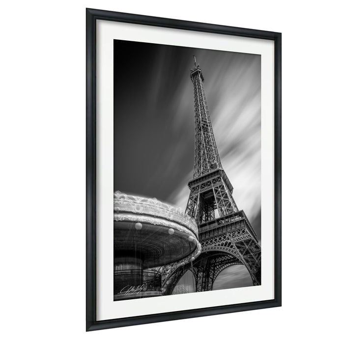 A black and white photograph of the Eiffel Tower in Paris, France, with a blurred background.