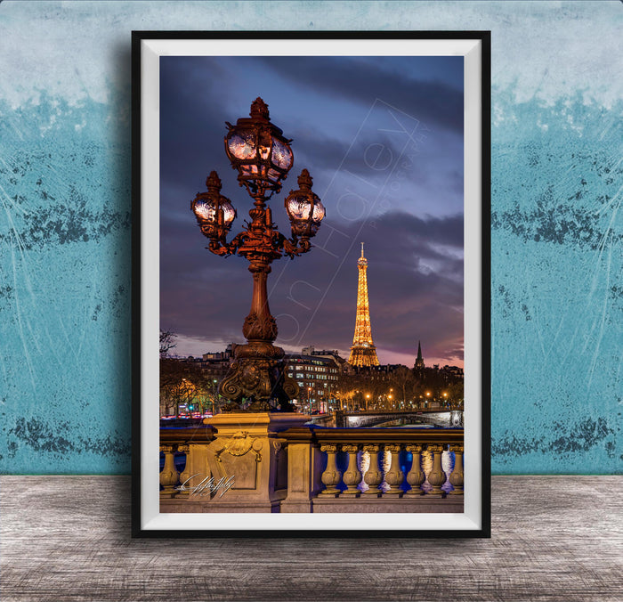 a cityscape with a lit-up lamppost and the Eiffel Tower in the background, set against a dark sky.