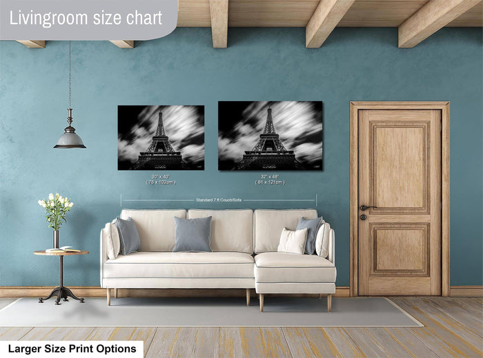 a living room with a white sofa, a wooden door, and two framed pictures of the Eiffel Tower hanging on the wall.