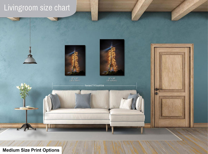 a living room with a white sofa, a wooden door, and a potted plant. The living room has a blue wall and a wooden ceiling. There are two framed photographs hanging on the wall, one of a rocket launch and the other of a building. The wall is painted in a light blue color, and the sofa is white.