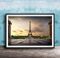 a framed photograph of the Eiffel Tower in Paris, France, with a dramatic sky in the background.