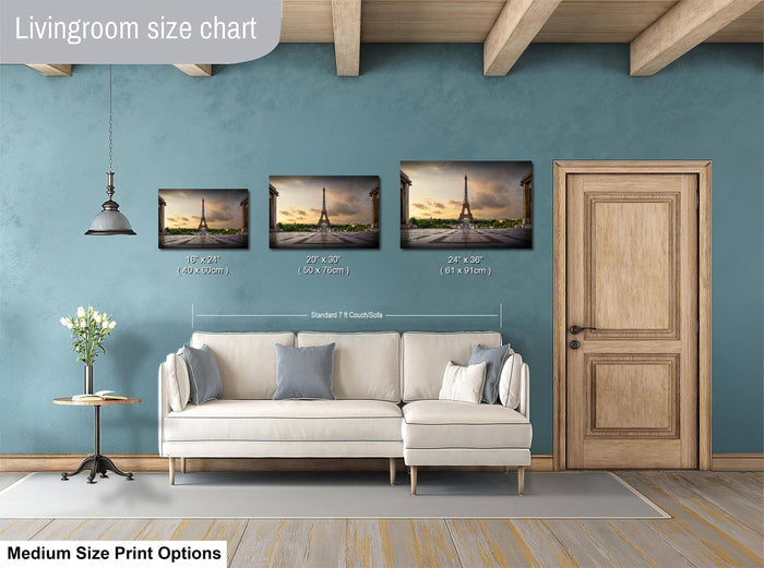 a living room with a white sofa and a wooden door. Above the sofa, there is a livingroom size chart that provides the dimensions of three framed prints of the Eiffel Tower. The chart indicates that the prints are of different sizes, ranging from 10x14 inches to 24x36 inches.