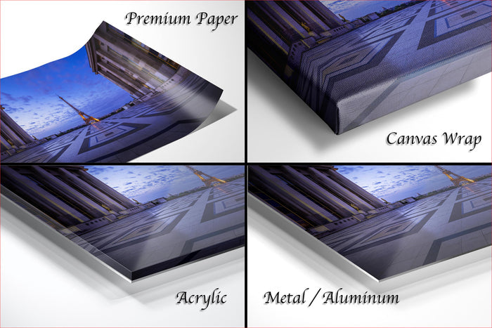 The image is a collage of four photos depicting the Eiffel Tower in Paris, France. The collage includes three close-up views of the iconic landmark and one panoramic view of the tower against a blue sky. The collage is labeled as "Premium Paper", "Canvas Wrap", "Acrylic", and "Metal/Aluminum" to describe the different materials used for the prints.