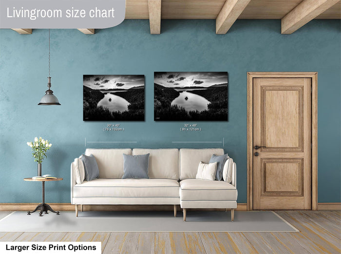 a living room with a white sofa, a wooden door, and two framed black and white landscape photographs hanging on the wall.