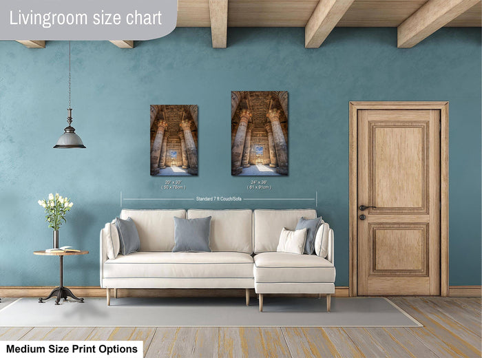 a living room with a white sofa, a wooden door, and a painting of a hallway with columns. The living room has a blue wall and a wooden floor.