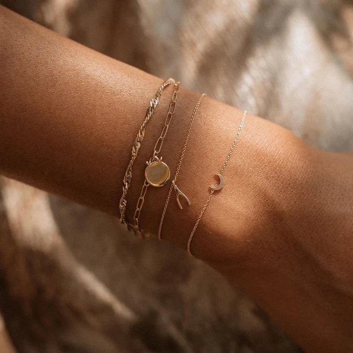 Everyday Little Crescent Moon Bracelet in 14k yellow gold, shown worn on hand
