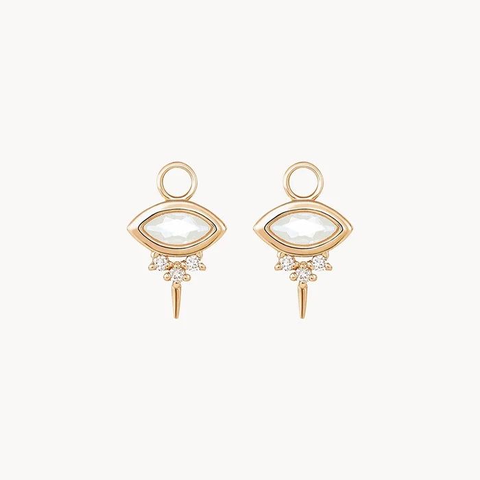 Front view of a pair of evil eye shaped earring charms with marquise-shaped rainbow moonstone at the centre and three small diamonds underneath followed by a small spike at the bottom displayed on a clean off-white background.