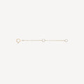 The Extender - 14k yellow gold by bluboho is a delicate accessory that features a clasp at one end and a loop at the other. It includes a small chain with two additional loops evenly spaced along its length. The extender is showcased against a plain white background.